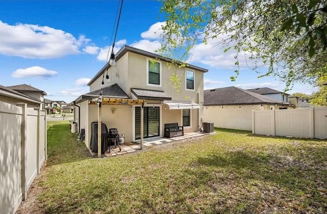 back of house with central AC unit, a pergola, a yard, and a patio area