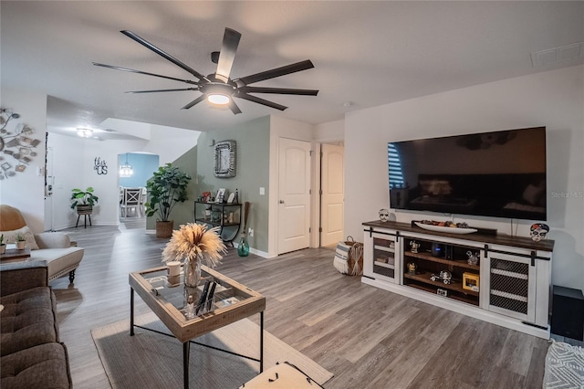 living room with wood-type flooring and ceiling fan