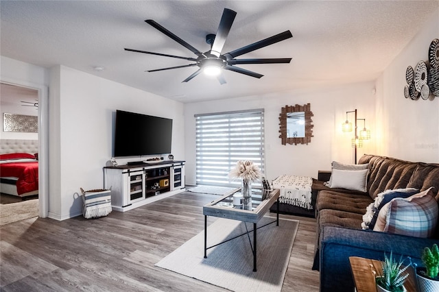 living room with a textured ceiling, hardwood / wood-style flooring, and ceiling fan