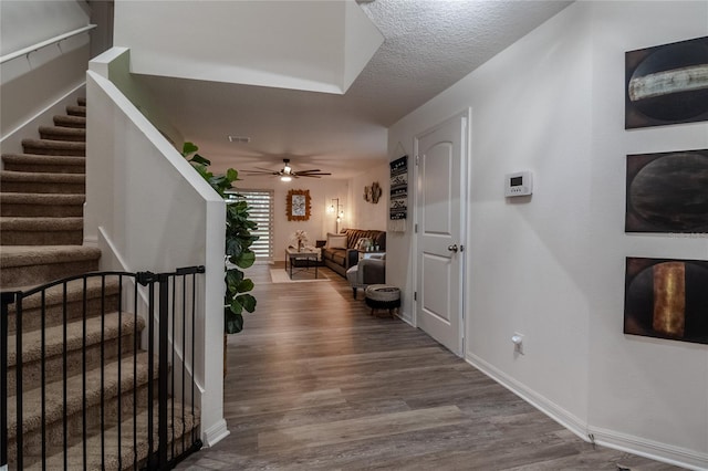 corridor featuring wood-type flooring and a textured ceiling