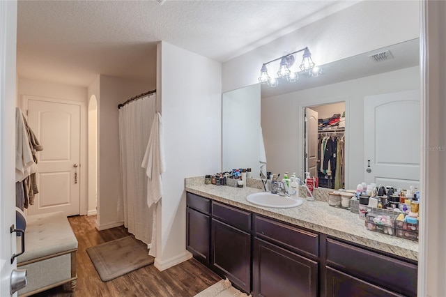 bathroom featuring wood-type flooring, vanity, and a textured ceiling