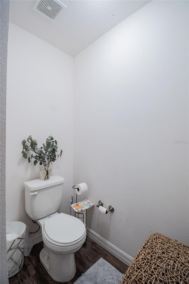 bathroom featuring wood-type flooring and toilet