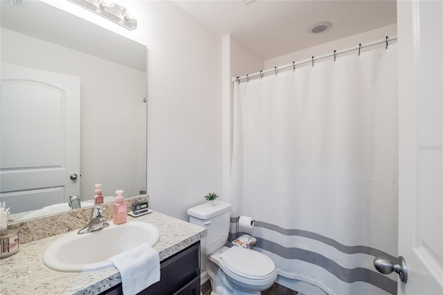 bathroom with vanity, a textured ceiling, and toilet