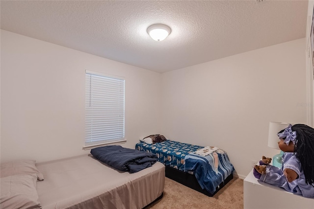 bedroom featuring light colored carpet and a textured ceiling