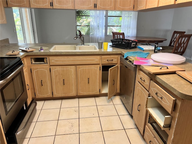 kitchen with sink, light tile patterned floors, a healthy amount of sunlight, and range with electric cooktop