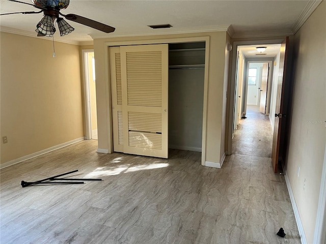 unfurnished bedroom with ornamental molding, a closet, and ceiling fan