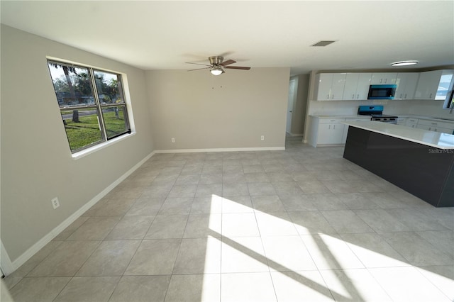 kitchen featuring range, light tile patterned floors, white cabinetry, and ceiling fan