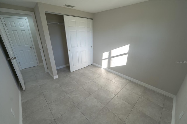 unfurnished bedroom with a closet and light tile patterned flooring