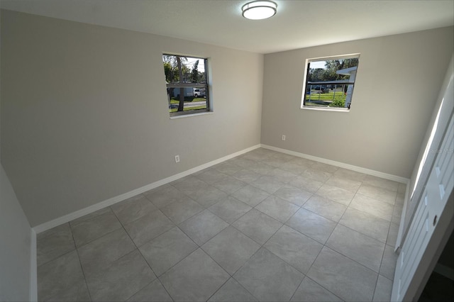 tiled spare room featuring a healthy amount of sunlight