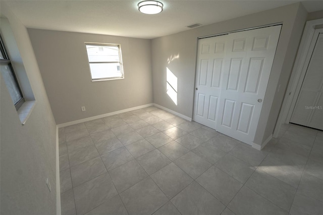 unfurnished bedroom featuring a closet and light tile patterned flooring