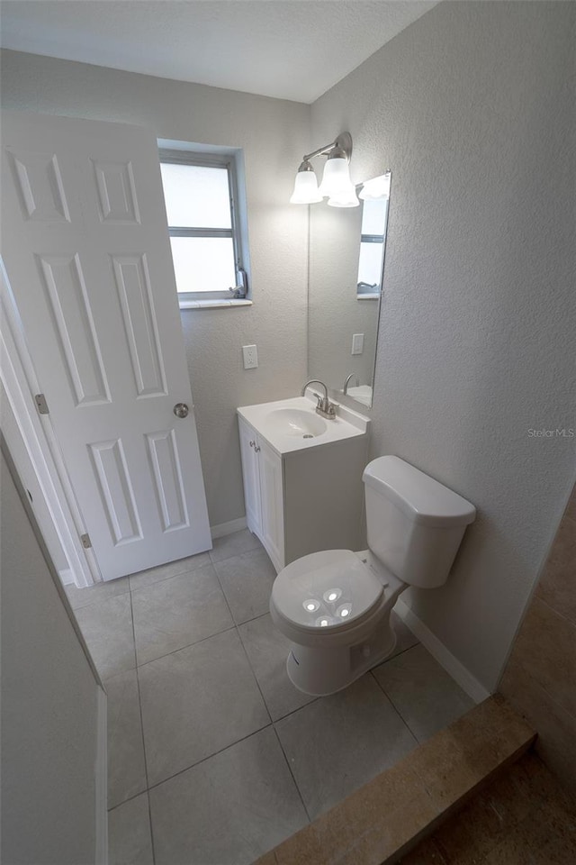 bathroom featuring toilet, vanity, and tile patterned floors