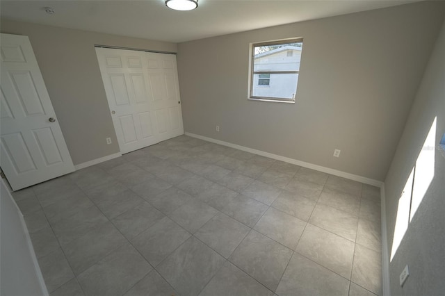 unfurnished bedroom with light tile patterned floors and a closet