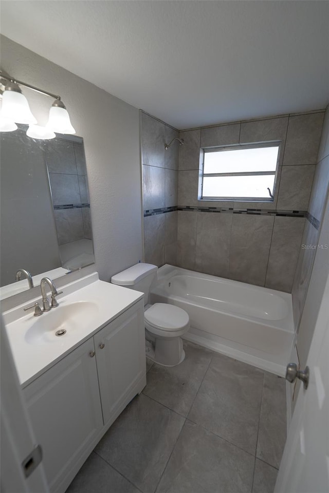 full bathroom featuring tile patterned flooring, vanity, toilet, and tiled shower / bath