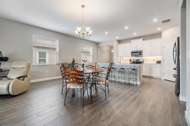 dining room featuring an inviting chandelier and light hardwood / wood-style flooring