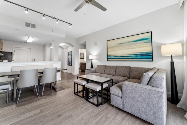 living room featuring light hardwood / wood-style flooring and ceiling fan