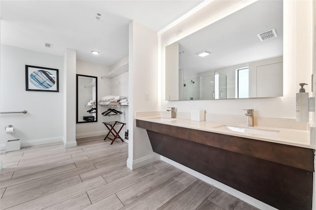 bathroom with hardwood / wood-style floors, walk in shower, and vanity