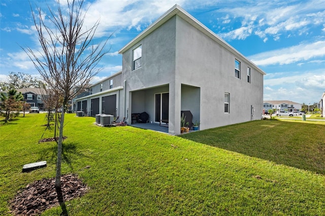 rear view of property featuring central air condition unit and a yard