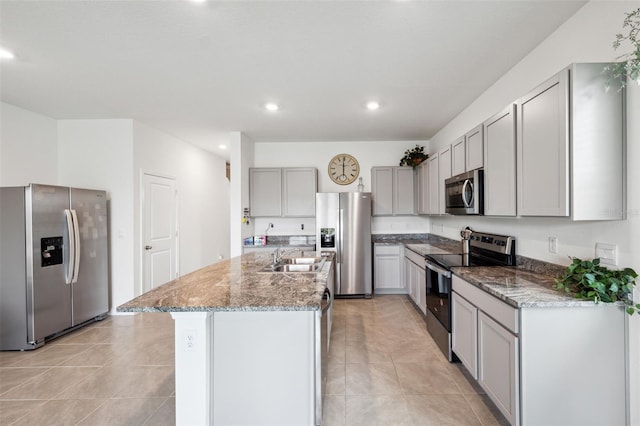 kitchen featuring gray cabinetry, stainless steel appliances, a kitchen island with sink, sink, and light tile patterned flooring