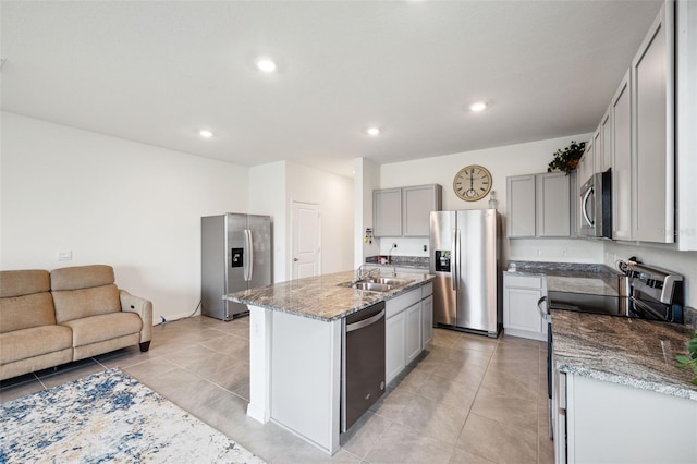 kitchen featuring gray cabinetry, sink, light tile patterned flooring, an island with sink, and stainless steel appliances