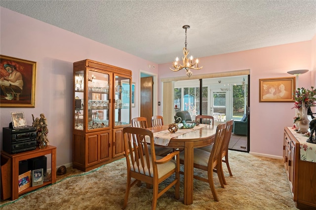 dining area featuring light carpet, a chandelier, and a textured ceiling