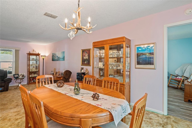 dining room with a textured ceiling and a chandelier