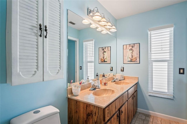 bathroom featuring plenty of natural light, toilet, and vanity