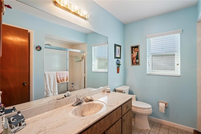 bathroom with plenty of natural light, vanity, a shower with shower door, and tile patterned flooring