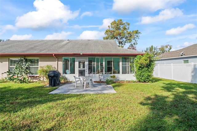 rear view of house with a lawn and a patio