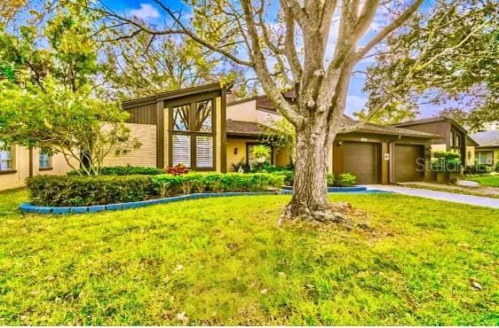 view of front of property featuring a garage and a front lawn