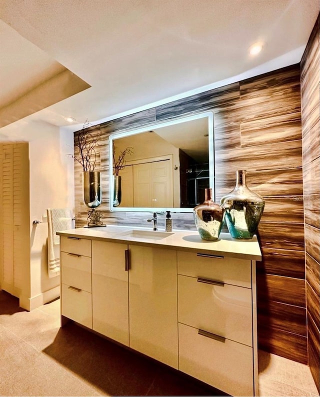 bathroom with vanity and wood walls