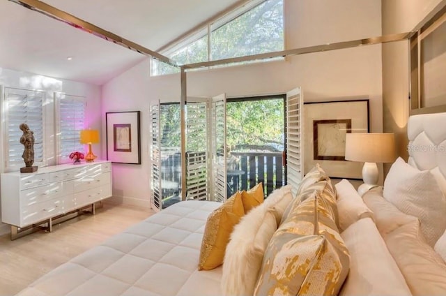 bedroom with access to exterior, high vaulted ceiling, and light hardwood / wood-style floors