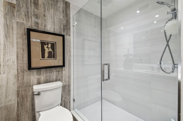 bathroom featuring toilet, tile walls, and walk in shower