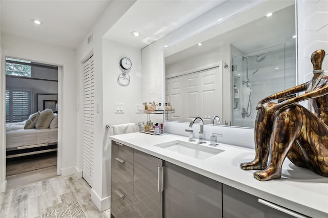 bathroom featuring vanity, wood-type flooring, and a shower with shower door