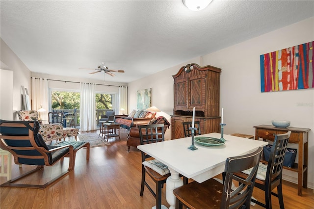 dining room with wood-type flooring, a textured ceiling, and ceiling fan