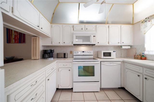 kitchen with white appliances, kitchen peninsula, light tile patterned floors, tasteful backsplash, and white cabinetry