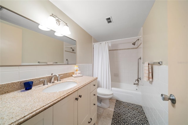 full bathroom with shower / bath combo, vanity, tile walls, tile patterned flooring, and toilet