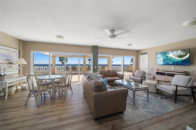 living room featuring a textured ceiling, dark hardwood / wood-style floors, and ceiling fan