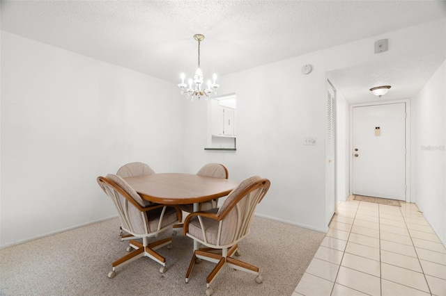 dining space with a textured ceiling, a notable chandelier, and light tile patterned flooring