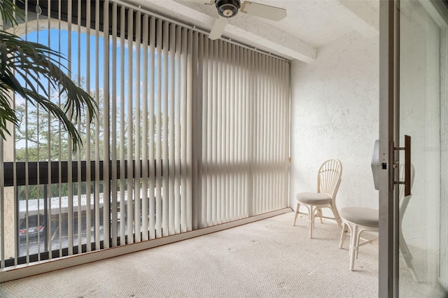 sunroom / solarium featuring beam ceiling and ceiling fan