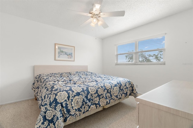 bedroom featuring a textured ceiling, ceiling fan, and light carpet