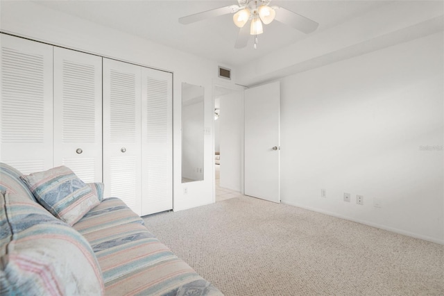 carpeted living room with ceiling fan