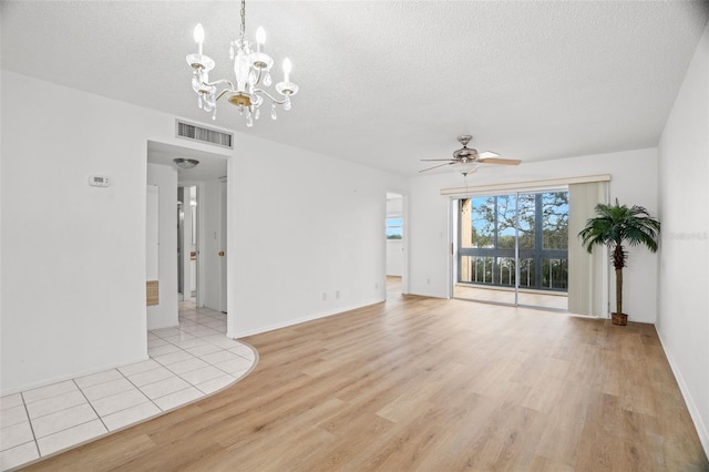 unfurnished living room with light wood-type flooring, visible vents, a textured ceiling, and ceiling fan with notable chandelier