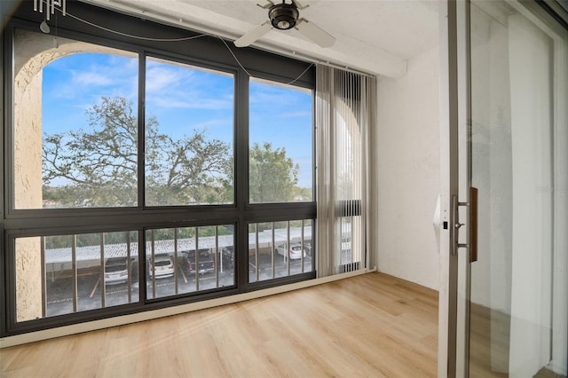 unfurnished sunroom featuring plenty of natural light and ceiling fan