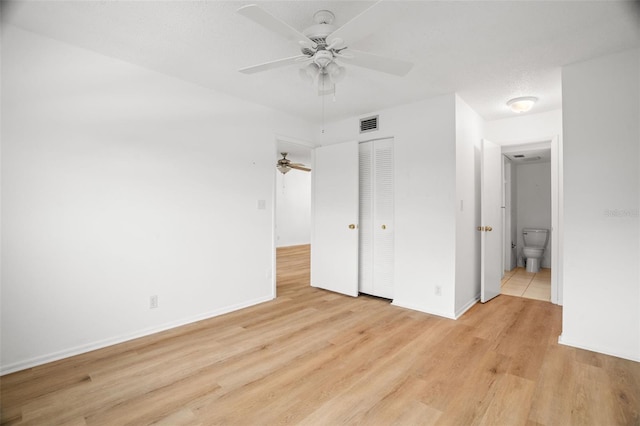 unfurnished bedroom featuring a closet, visible vents, baseboards, and light wood finished floors