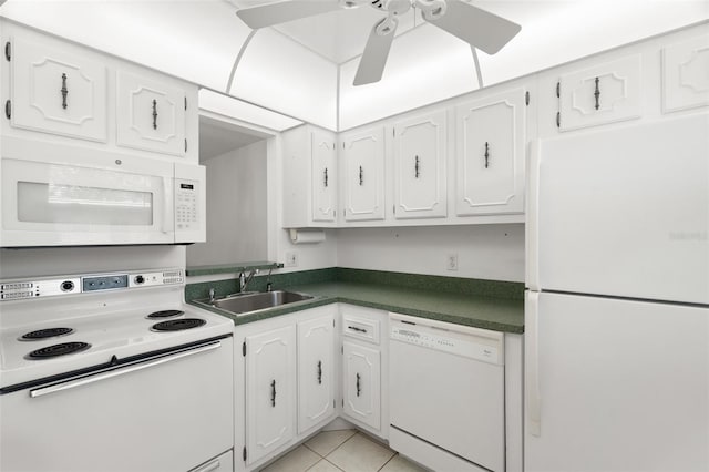 kitchen with white appliances, dark countertops, a sink, and white cabinets