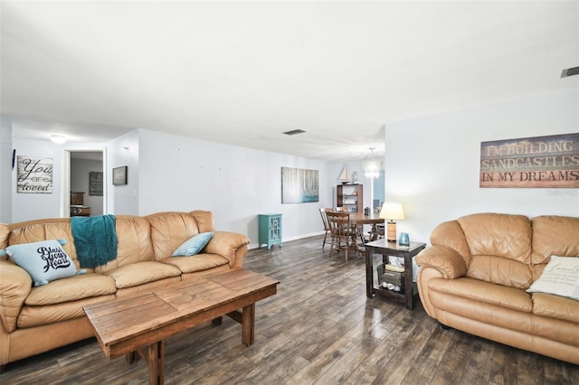 living room with a notable chandelier and dark hardwood / wood-style floors