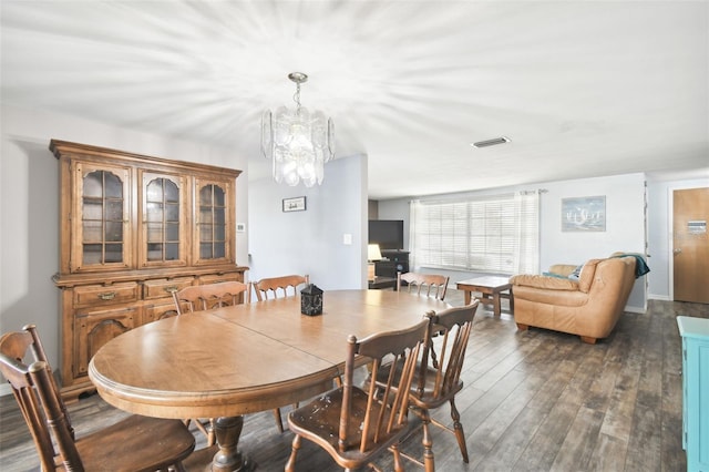 dining area featuring dark hardwood / wood-style floors and an inviting chandelier