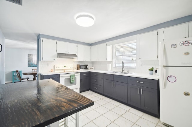 kitchen featuring light tile patterned flooring, sink, tasteful backsplash, white appliances, and white cabinets