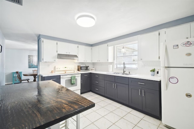 7511 Tyson Dr, Port Richey, FL 34668 - kitchen featuring white appliances, under cabinet range hood, a sink, and decorative backsplash