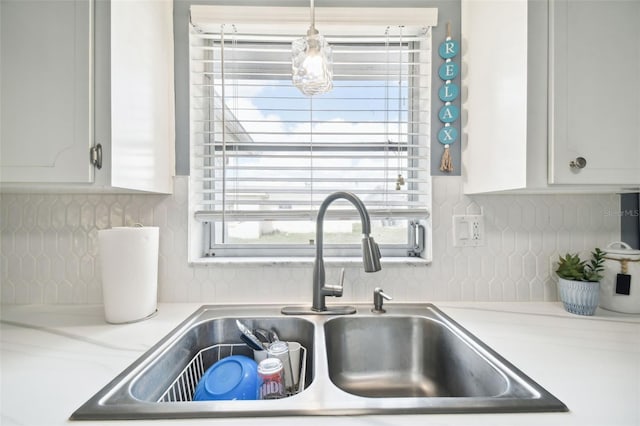 7511 Tyson Dr, Port Richey, FL 34668 - kitchen view of a sink, tasteful backsplash, light countertops, and white cabinets